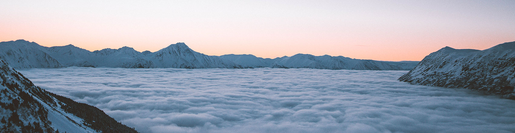 View of mountains surrounding Whittier with the town covered below in a blanket of fog.